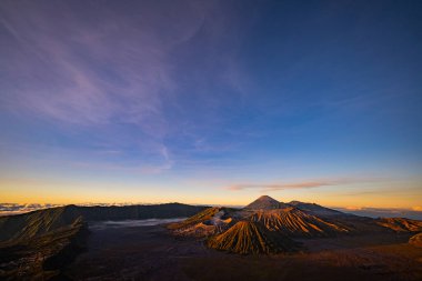 Güneşin doğuşunda mavi gökyüzü olan Bromo volkanları 
