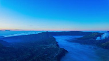 Penanjakan Peak Bromo 'da zaman atlaması, en yüksek bakış açısı, çok güzel volkanları görebilirsiniz. Bromo volkanları üzerinde inanılmaz renkli ilk ışık parlıyor. Volkanı çevreleyen bir sis denizi.