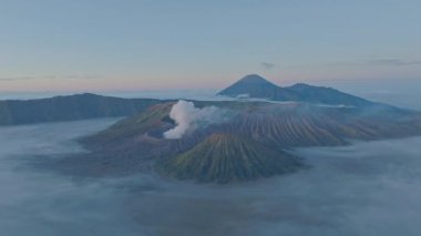 Bromo Dağı 'nın zirvesinden hava manzarası sürekli kraterinden beyaz duman püskürtüyor. Bromo Volkanları, Endonezya 'da hizalanmıştı. Kraterin etrafındaki bayırın güzelliği....