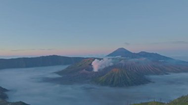 Bromo Dağı 'nın zirvesinden hava manzarası sürekli kraterinden beyaz duman püskürtüyor. Bromo Volkanları, Endonezya 'da hizalanmıştı. Kraterin etrafındaki bayırın güzelliği....