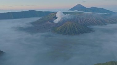 Bromo Dağı 'nın zirvesinden hava manzarası sürekli kraterinden beyaz duman püskürtüyor. Bromo Volkanları, Endonezya 'da hizalanmıştı. Kraterin etrafındaki bayırın güzelliği....