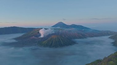 Bromo Dağı 'nın zirvesinden hava manzarası sürekli kraterinden beyaz duman püskürtüyor. Bromo Volkanları, Endonezya 'da hizalanmıştı. Kraterin etrafındaki bayırın güzelliği....