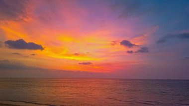 Gün batımında denizin üzerinde çarpıcı renkli bulutların zaman geçişi 