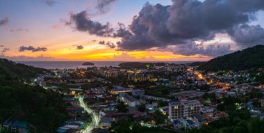 Hava manzaralı bulutlar güneş batarken güzel gökyüzünü karartır. Sahildeki ışıklar alacakaranlık yaklaşırken yanmaya başlıyor. Turistleri barındıran pek çok bina, tatil köyü ve otel var..