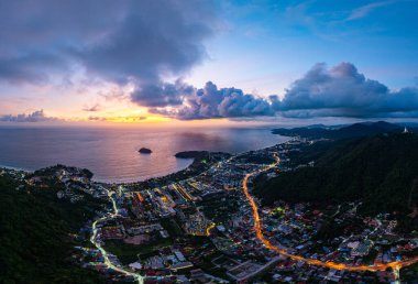 Hava manzaralı bulutlar güneş batarken güzel gökyüzünü karartır. Sahildeki ışıklar alacakaranlık yaklaşırken yanmaya başlıyor. Turistleri barındıran pek çok bina, tatil köyü ve otel var..