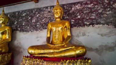 Wat Phra Kaew duvarı boyunca dizilmiş altın Buda heykelleri var. Duvarlarda Ramayana 'nın hikayesini tasvir eden freskler var. Tavan kırmızı arka planda altın desenlerle süslenmiş..