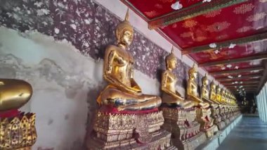 Wat Phra Kaew duvarı boyunca dizilmiş altın Buda heykelleri var. Duvarlarda Ramayana 'nın hikayesini tasvir eden freskler var. Tavan kırmızı arka planda altın desenlerle süslenmiş..