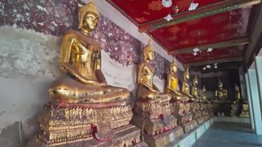 Wat Phra Kaew duvarı boyunca dizilmiş altın Buda heykelleri var. Duvarlarda Ramayana 'nın hikayesini tasvir eden freskler var. Tavan kırmızı arka planda altın desenlerle süslenmiş..