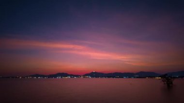 Denizin üzerindeki günbatımında zaman su gibi akıp geçiyor. Doğanın yüksek kaliteli görüntüleri. Romantik gökyüzünün günbatımı sahnesi. Yaratıcı doğa ve seyahat konsepti için arka planda bulut var.