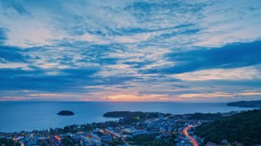 Hava hiperlapse görüntüsü güneş batarken güzel gökyüzünde bulutlar oluşturur. Sahildeki ışıklar alacakaranlık yaklaşırken yanmaya başlıyor. Turistleri barındıran pek çok bina, tatil köyü ve otel var.