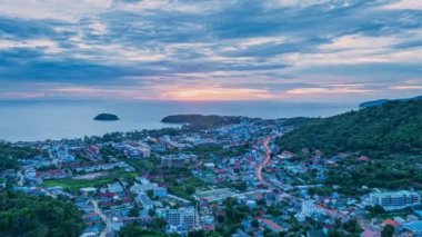 Hava hiperlapse görüntüsü güneş batarken güzel gökyüzünde bulutlar oluşturur. Sahildeki ışıklar alacakaranlık yaklaşırken yanmaya başlıyor. Turistleri barındıran pek çok bina, tatil köyü ve otel var.