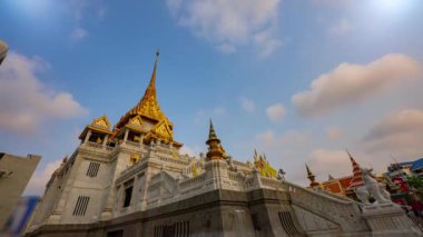 Bangkok, Tayland 'da Wat Traimit üzerinde mavi gökyüzünde beyaz bulutların zaman akışı.
