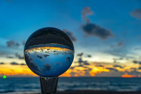 stock image This time lapse was captured using a crystal ball to capture the colorful sky. stunning sunset at the sea in twilight.