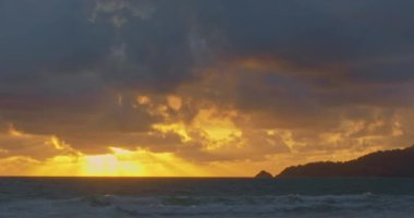 Patong Sahili 'ndeki hava manzaralı altın gün batımı, Phuket eskiden dünyanın en iyi turizm beldelerinden biriydi. Bulutlar Patong plajı üzerinde hareket ediyor. Phuket Tayland ve 4K çözünürlüklü görüntüler..