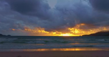 Patong Sahili 'ndeki hava manzaralı altın gün batımı, Phuket eskiden dünyanın en iyi turizm beldelerinden biriydi. Bulutlar Patong plajı üzerinde hareket ediyor. Phuket Tayland ve 4K çözünürlüklü görüntüler..