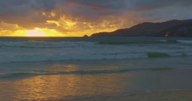 Patong Sahili 'ndeki hava manzaralı altın gün batımı, Phuket eskiden dünyanın en iyi turizm beldelerinden biriydi. Bulutlar Patong plajı üzerinde hareket ediyor. Phuket Tayland ve 4K çözünürlüklü görüntüler..
