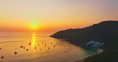 Nai Harn plajı Phuket 'te gün batımında hava manzarası güzel bulutlu. Renkli romantik gökyüzü günbatımı sahnesi. Tatlı gökyüzü deniz arkasını kaplıyor. Nai Harn sahilindeki marinada bir sürü yat var.
