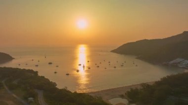 Nai Harn plajı Phuket 'in üzerinde havadan hiper ışık saçan güneş ışığı. Panorama manzaralı turistik yerler Promthep Cape, Man Island, Yanui plajı, yel değirmenleri ve Nai Harn Sahili.
