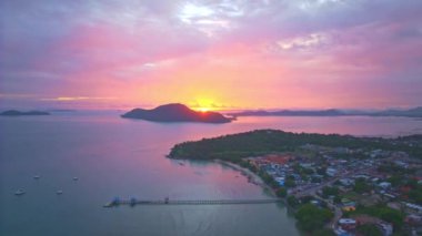 Gökyüzü, adaların üzerindeki alevler gibi görünüyordu. Panorama manzarası, adanın üzerindeki görkemli pembe gökyüzü. Muhteşem doğa bulutları. Soyut doğa arkaplanı.