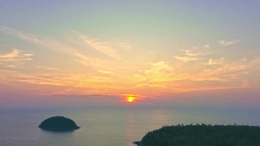 Layan plajı Phuket 'teki Kala adasının üzerinde günbatımının renkli gökyüzü. Doğa videosu çok kaliteli. Gün batımında gökyüzünde romantik gökyüzü manzarası, gökyüzünde bulutlar....