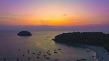 Layan plajı Phuket 'teki Kala adasının üzerinde günbatımının renkli gökyüzü. Doğa videosu çok kaliteli. Gün batımında gökyüzünde romantik gökyüzü manzarası, gökyüzünde bulutlar....