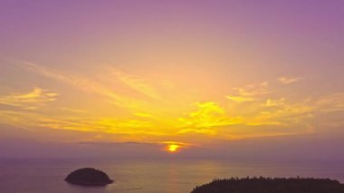 Layan plajı Phuket 'teki Kala adasının üzerinde günbatımının renkli gökyüzü. Doğa videosu çok kaliteli. Gün batımında gökyüzünde romantik gökyüzü manzarası, gökyüzünde bulutlar....