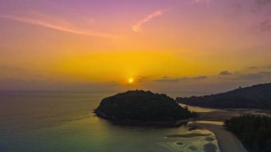 Layan plajı Phuket.video 4K 'da Kala adasının üzerinde gün batımının havadan hipersüratli görüntüsü. Doğa videosu çok kaliteli. Gün batımında gökyüzünde gökyüzünde bulutlu romantik gökyüzü manzarası.