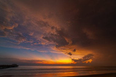 Deniz üzerinde güzel gün batımında inanılmaz renkli bir bulut. Güzel bir gündoğumu manzarası. Ufuk üzerinde doğanın inanılmaz ışığı..
