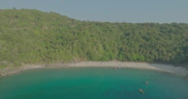 Huzurlu bir sahil üzerinde sakin, yumuşak dalgalar ve yumuşak, ince bulutlarla süslenmiş bir gökyüzü. Işık, su ve kuma güzel bir şekilde yansıyor, rahatlatıcı ve resimsel bir sahne yaratıyor..