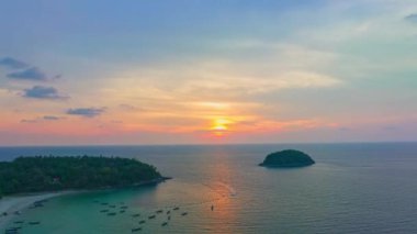 Adanın yukarısındaki günbatımında havadan hiperhız manzarası güzel gökyüzü. Güneş, Kata sahilindeki Pu adasının yanında denize batıyor. Phuket Tayland ve 44k hisse senedi videosu seyahat konsepti.. 