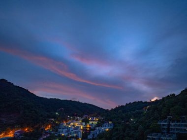 Güneşin doğuşunda dağlar manzaralı ve bulutlu gökyüzü 