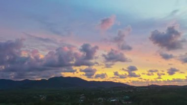 Gün batımında renkli bir gökyüzünde süzülen bulutların hava görüntüsü