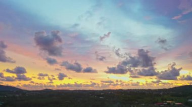 Gün batımında renkli gökyüzünde süzülen bulutların hava görüntüsü.