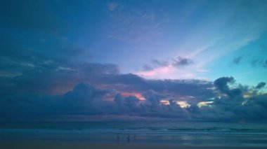 Gün batımında denizin üzerinde koyu mavi bulutların bir zaman atlaması.