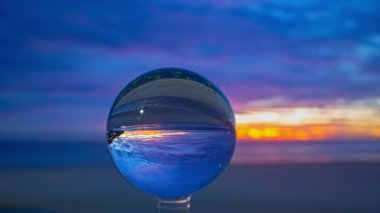 Camdan bir küre içindeki renkli akşam bulutlarının zaman aşımı