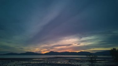 Bulutların dağların tepesindeki güzel günbatımını hızlandırır.