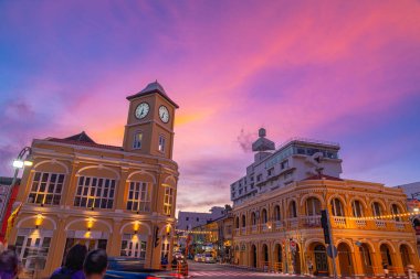 Phuket 'in eski kasabasındaki klasik binanın üzerindeki mavi gökyüzünde pembe bulut. Romantik güzel gökyüzü günbatımı sahnesi. Arka planda yavaş hareket eden bulut. Saat kulesi Phuket 'in simgesidir..