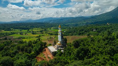 Büyük Buda Brahma Panyo, Doi Luang dağının önünde dikiliyor, Chiang Mai doğal ortamdaki huzur ve maneviyatı sembolize ediyor. Yüksek dağ arkaplanı