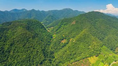 Mavi gökyüzünün altında, kabarık bulutlu Verdant Dağı manzarasının hava hiper yanılma görüntüsü 