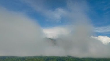 Mavi gökyüzündeki beyaz bulutların hiperhızlandırılmış hava manzarası Chiang Dao Dağı 'nın zirvesini kaplar. Dağın tepesindeki bulutlar şekil değiştirip duruyordu. Bulutlu Gök Altındaki Sisli Dağ
