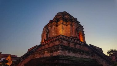 Zaman aşımı Tayland 'ın Chiang Mai kentindeki tarihi Wat Chedi Luang tapınağının günbatımında çarpıcı bir görüntüsü. Antik tuğla yapı görkemli bir şekilde duruyor alacakaranlık renkli gökyüzüne karşı.