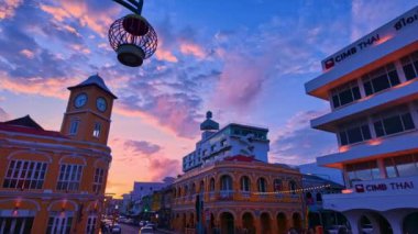 Phuket 'in eski kasabasındaki klasik binanın üzerindeki mavi gökyüzünde pembe bulut. Romantik güzel gökyüzü günbatımı sahnesi. Arka planda yavaş hareket eden bulut. Saat kulesi Phuket 'in simgesidir..