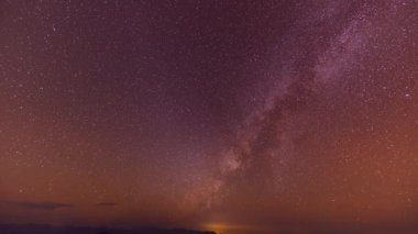 Sonbaharda gece vakti Samanyolu 'nun dağların üzerinde süratle ilerler. Dağ vadisiyle manzara, alçak bulutlar, Samanyolu ile mor yıldızlı gökyüzü. Samanyolu Tayland 'ın kuzeyinde soğuk bir gecede parlıyor.