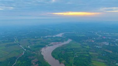 Bereketli bir vadide dolambaçlı bir nehrin üzerinde sakin bir gün doğumunun havadan hiper görüntüsü.