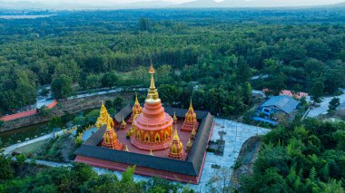 Doi Phra Chan (Daibutsu) perspektifinden yapılan Phra Yai Wat Phra karmaşık altın kuleleri ile büyüleyici bir Tayland tapınağı sergilenmektedir. Gün batımında çekilen karmaşık altın mimari ile..