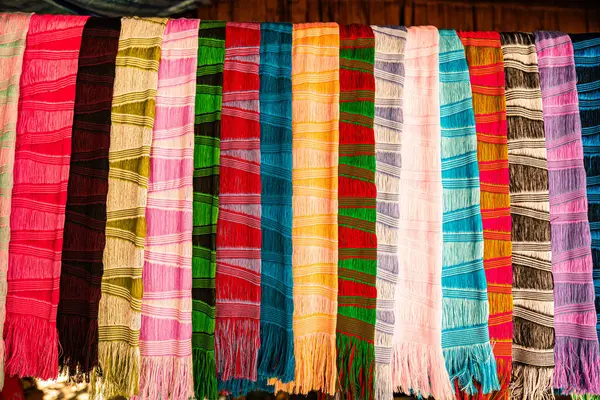 Karmaşık desenlere sahip kalın ve zengin renklerden oluşan geleneksel el dokuması kumaşların canlı bir gösterisi. Kuzeydeki dokuma geleneklerinin zanaatkarlığı ve kültürel mirası
