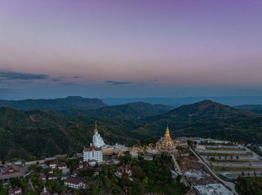 Hava manzarası gün batımında muhteşem Büyük Beyaz Buda heykelleri. Wat Phachonkeaw 'un güzel altın köşkü Tayland' ın çok güzel ve ünlü bir simgesi olan tepede mücevherler ve taşlarla süslenir..