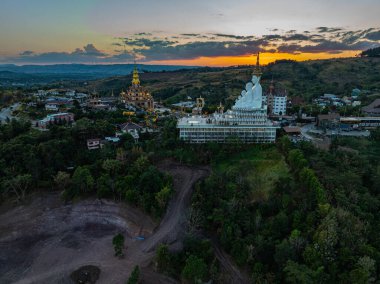Hava manzarası gün batımında muhteşem Büyük Beyaz Buda heykelleri. Wat Phachonkeaw 'un güzel altın köşkü Tayland' ın çok güzel ve ünlü bir simgesi olan tepede mücevherler ve taşlarla süslenir..