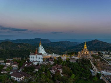 Hava manzarası gün batımında muhteşem Büyük Beyaz Buda heykelleri. Wat Phachonkeaw 'un güzel altın köşkü Tayland' ın çok güzel ve ünlü bir simgesi olan tepede mücevherler ve taşlarla süslenir..