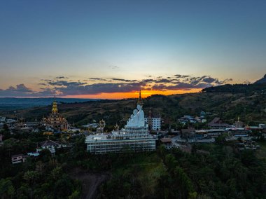 Hava manzarası gün batımında muhteşem Büyük Beyaz Buda heykelleri. Wat Phachonkeaw 'un güzel altın köşkü Tayland' ın çok güzel ve ünlü bir simgesi olan tepede mücevherler ve taşlarla süslenir..
